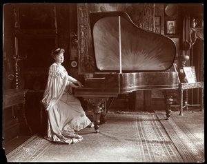 La signora I. M. Clark seduta a un pianoforte a coda, 1904